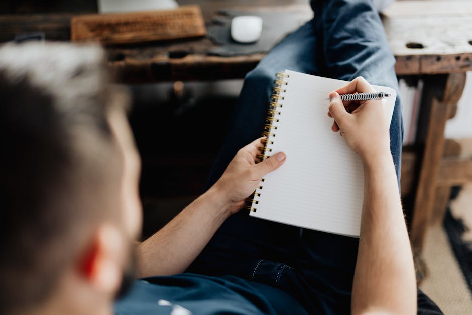 Person sitting on a sofa with a notebook, reflecting and relaxing