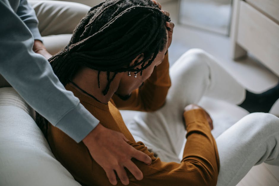Person offering comfort with a gentle hand on a shoulder