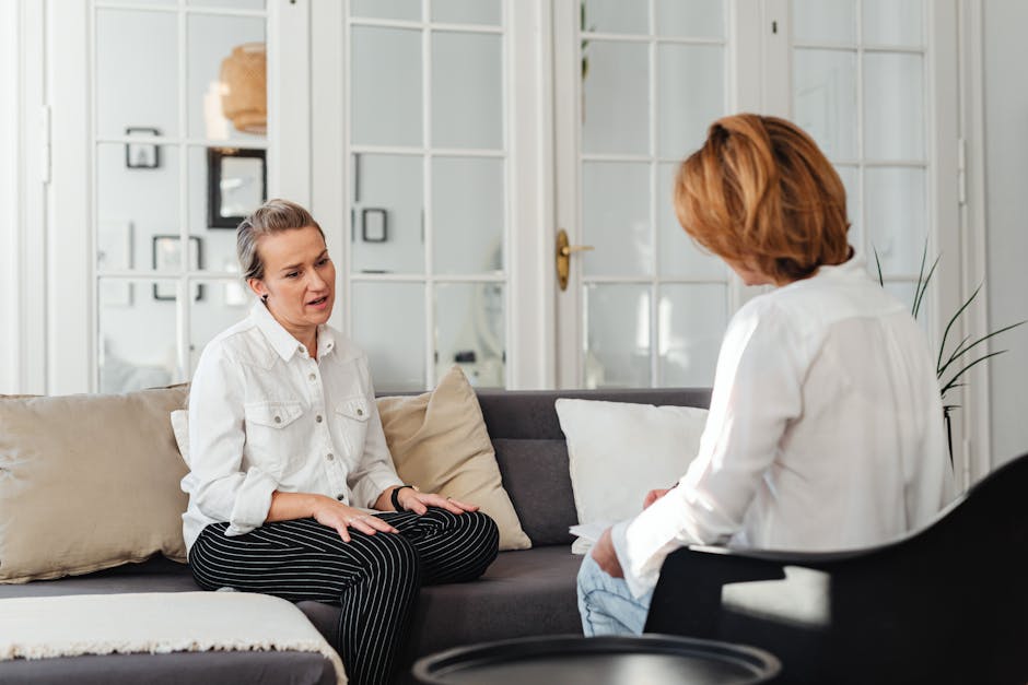 Two people talking supportively on a sofa, comforting conversation