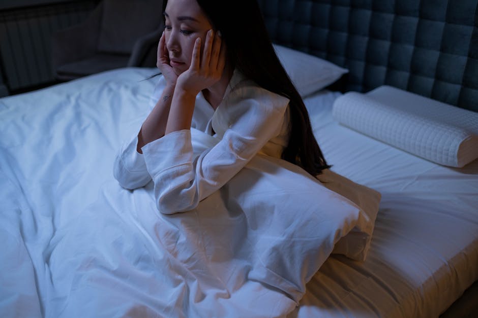 Person lying awake in bed at night, unable to sleep