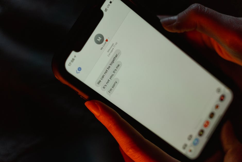 Hands holding a phone with messages and evidence of harassment