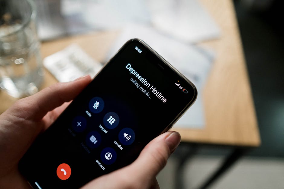 Person lost in obsessive thoughts, staring at a phone in a dim room