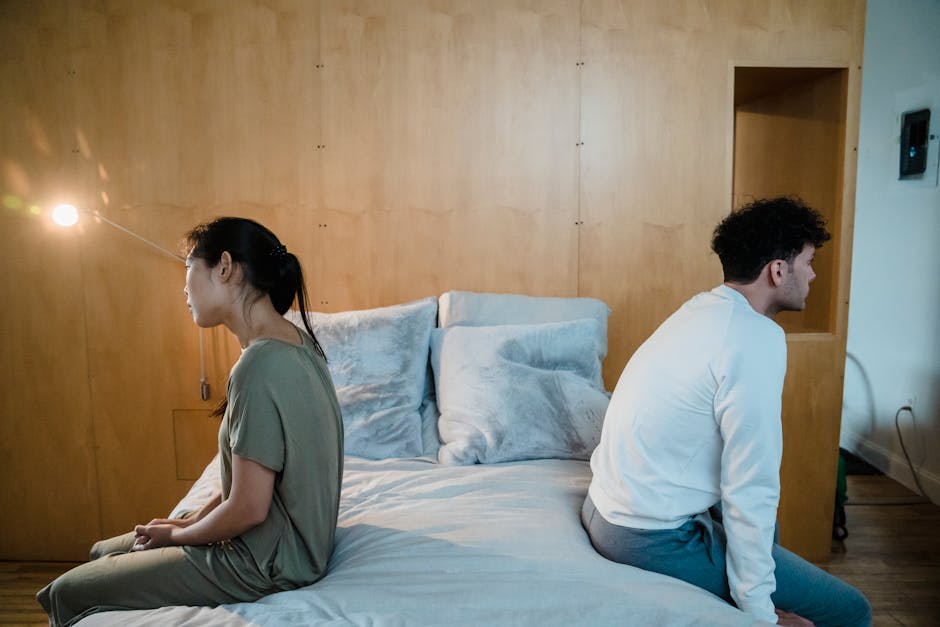 Couple sitting apart in a tense atmosphere, illustrating a relationship with commitment but little intimacy