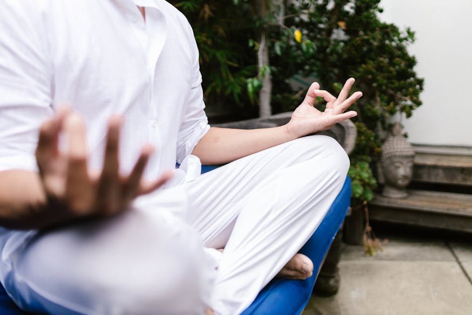 Person meditating in a calm indoor setting, focused on breath and present moment