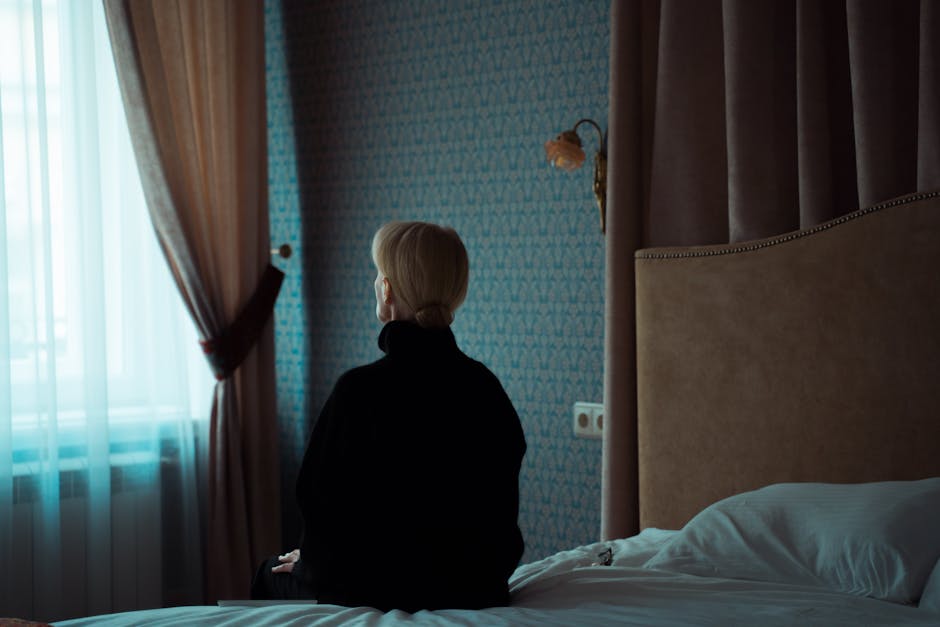 Person sitting alone in a quiet room, looking reflective and detached