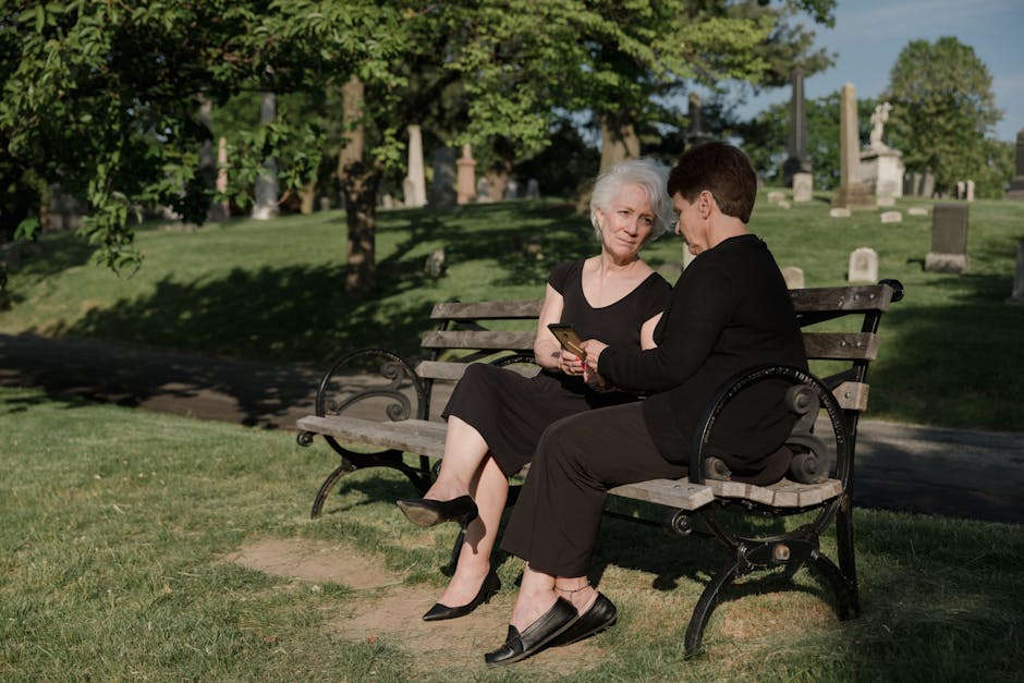 Two friends talking supportively on a park bench