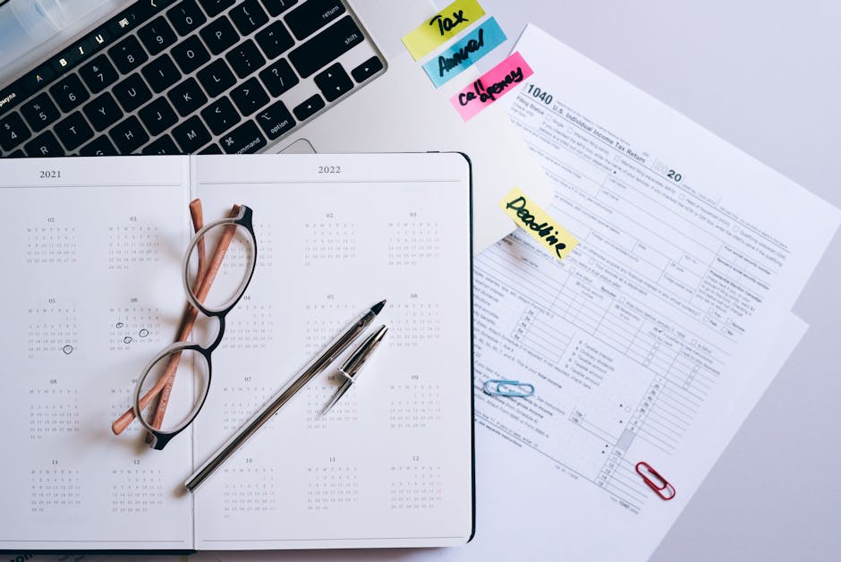 Adulte au bureau avec agenda et ordinateur, illustrant les difficultés d’organisation et le TDAH à l’âge adulte