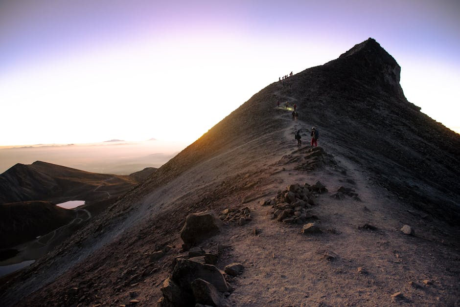 Person standing at sunrise on a mountain summit, symbolizing hope, meaning and inner strength