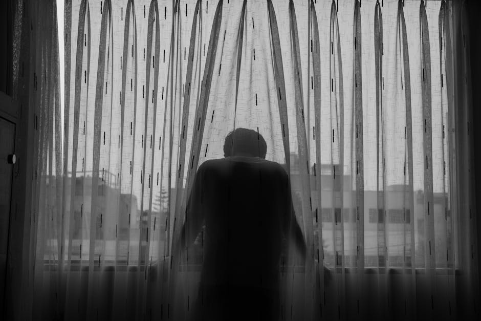 Personne assise seule près d'une fenêtre, regard perdu, illustrant le sentiment de vide intérieur