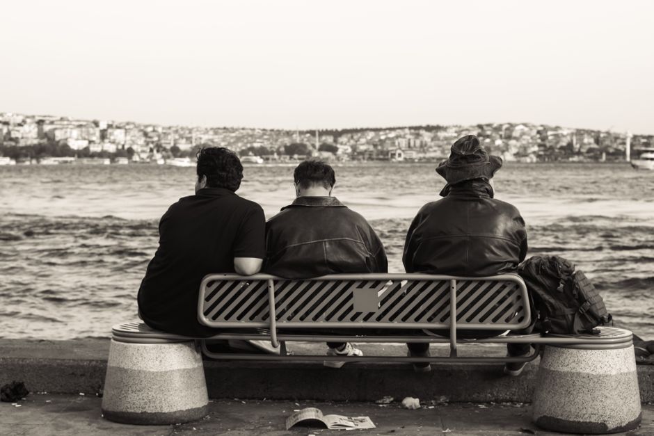 Person observing a group from the side in a thoughtful way