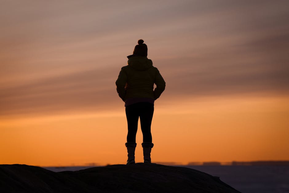 Silhouette seule dans un paysage ouvert au lever du soleil, évoquant la reconstruction et l'espoir