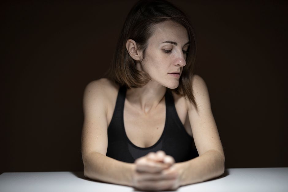 Person looking down with a thoughtful, insecure expression
