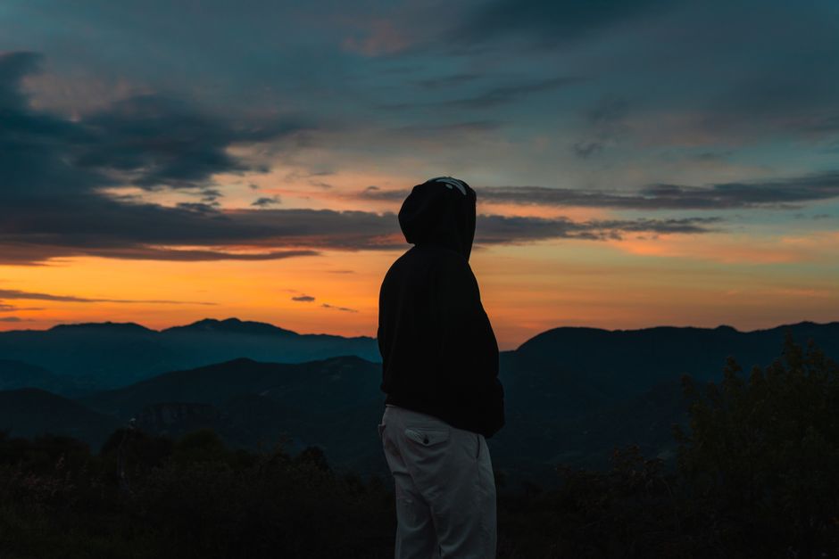 Personne contemplant un paysage au lever du soleil, symbole de quête de sens