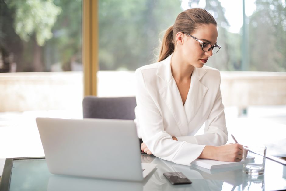 Confident professional woman working at a desk, symbolizing success in career and social life
