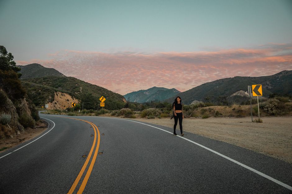 Person walking alone on a road at sunset