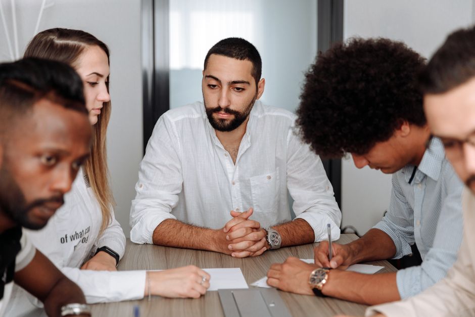 A workplace team meeting showing collaboration, belonging, and recognition