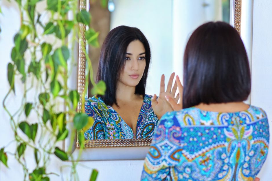 Person reflecting in a mirror, symbolizing self-image and ego