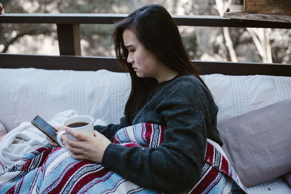 Woman comparing herself on social media on smartphone