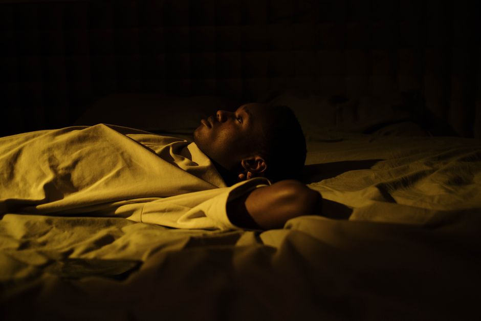 Person lying awake in bed unable to sleep at night