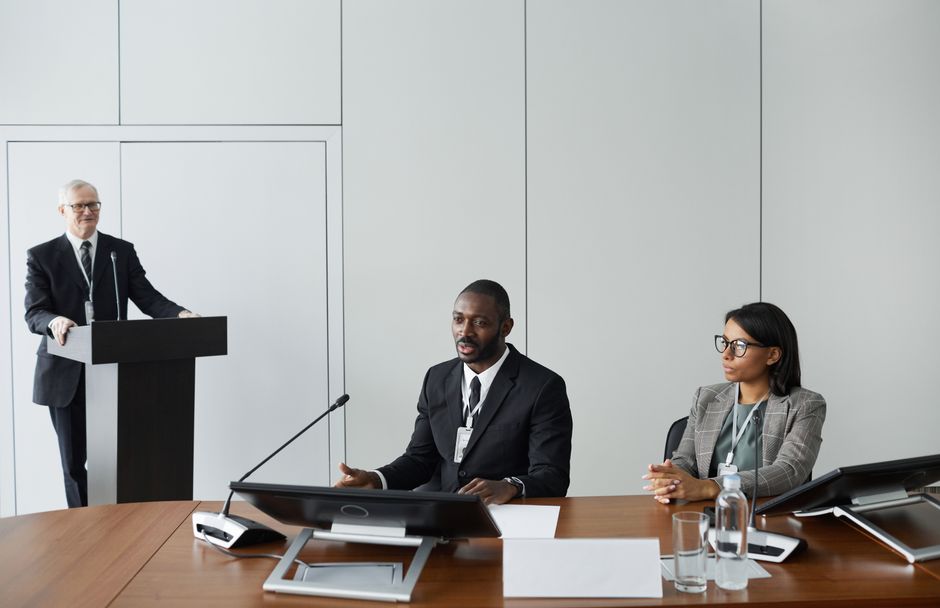Confident business person speaking in a meeting with colleagues listening