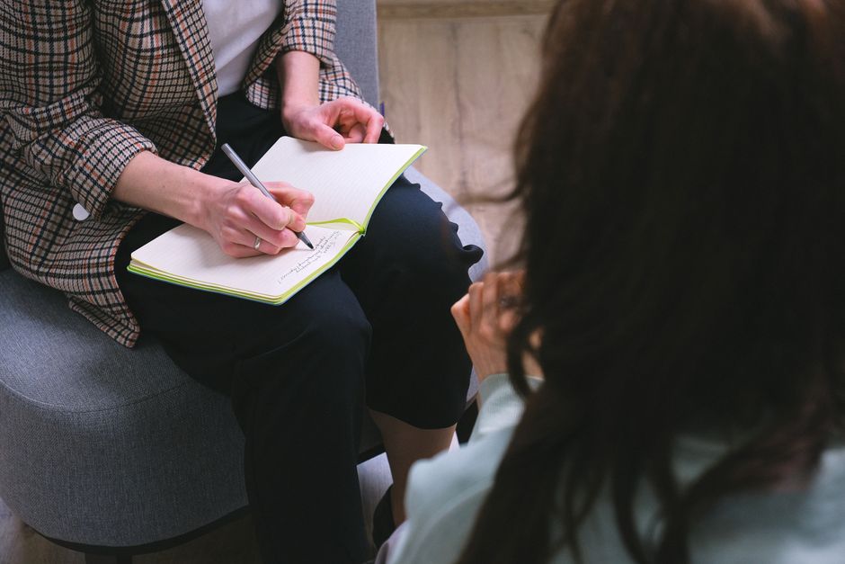 Therapy session with notebook and cognitive behavioral tools