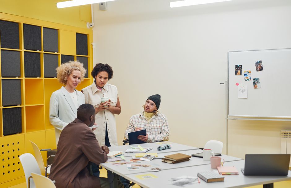 Groupe de personnes en réunion de travail autour d’un tableau de brainstorming