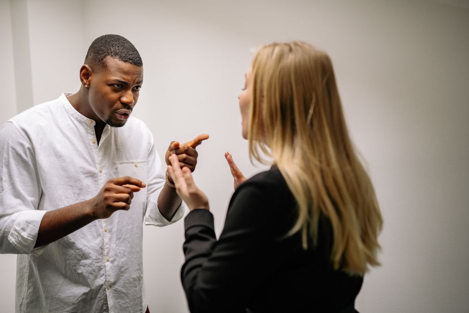 Two people in a tense conversation, illustrating ego defensiveness and conflict