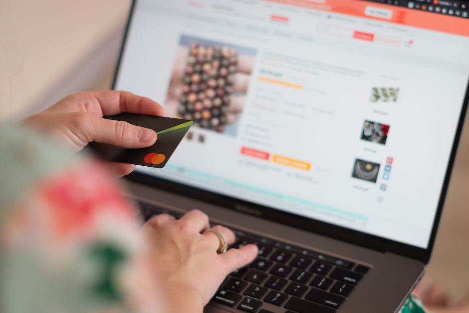 Person looking at online shopping on a laptop with credit cards nearby