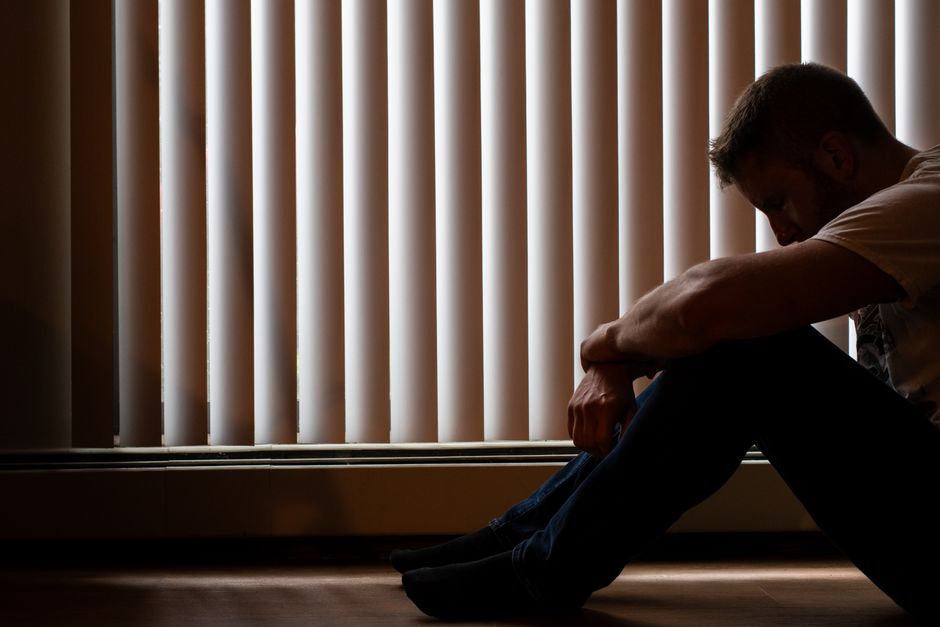 Silhouette réfléchie dans une ambiance sombre évoquant la dépression et le doute