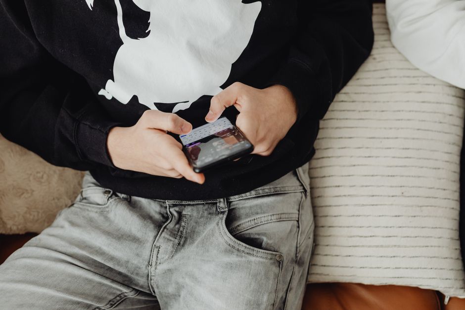 Personne utilisant un smartphone pour faire défiler les réseaux sociaux, avec une ambiance de comparaison numérique