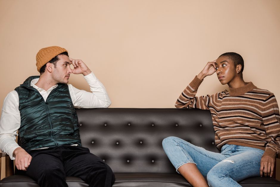 Couple in tense conversation at home, emotional distance and conflict
