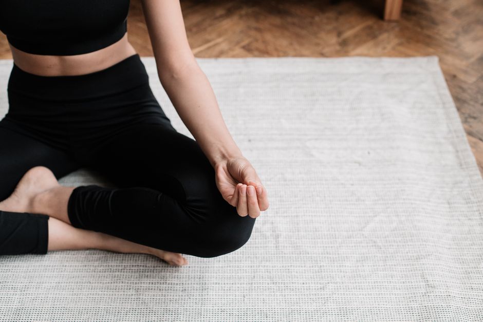 Person sitting on a floor practicing calm breathing during anxiety
