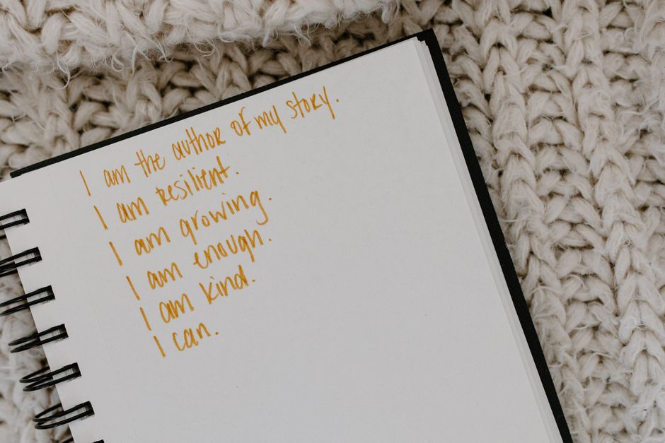 Person writing in a notebook during a self-reflection moment