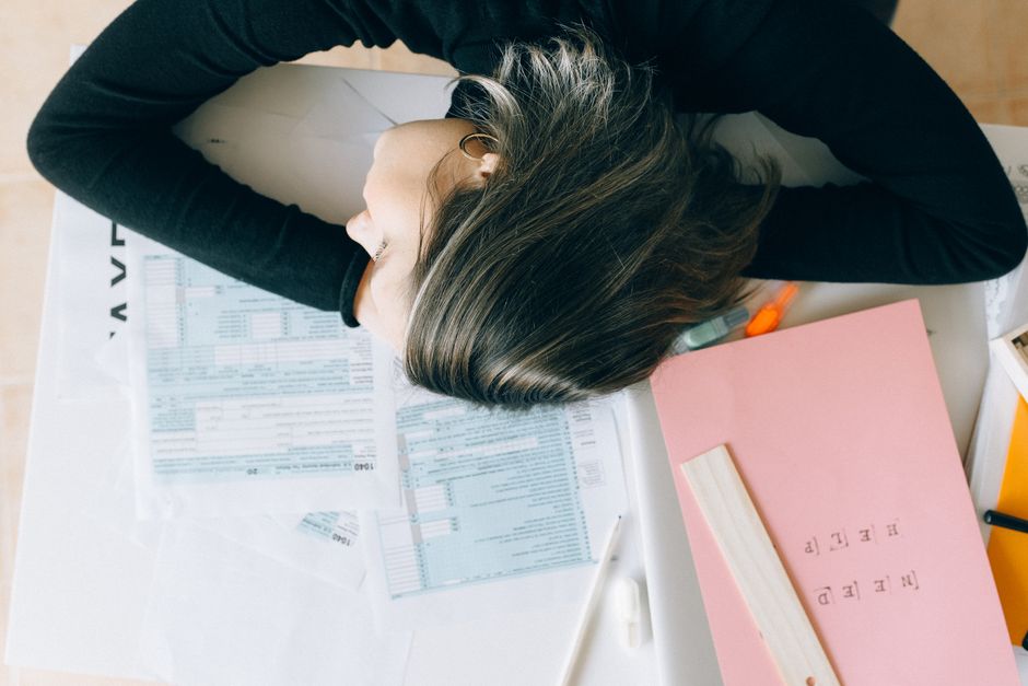 Person sitting at desk overwhelmed by tasks and procrastination