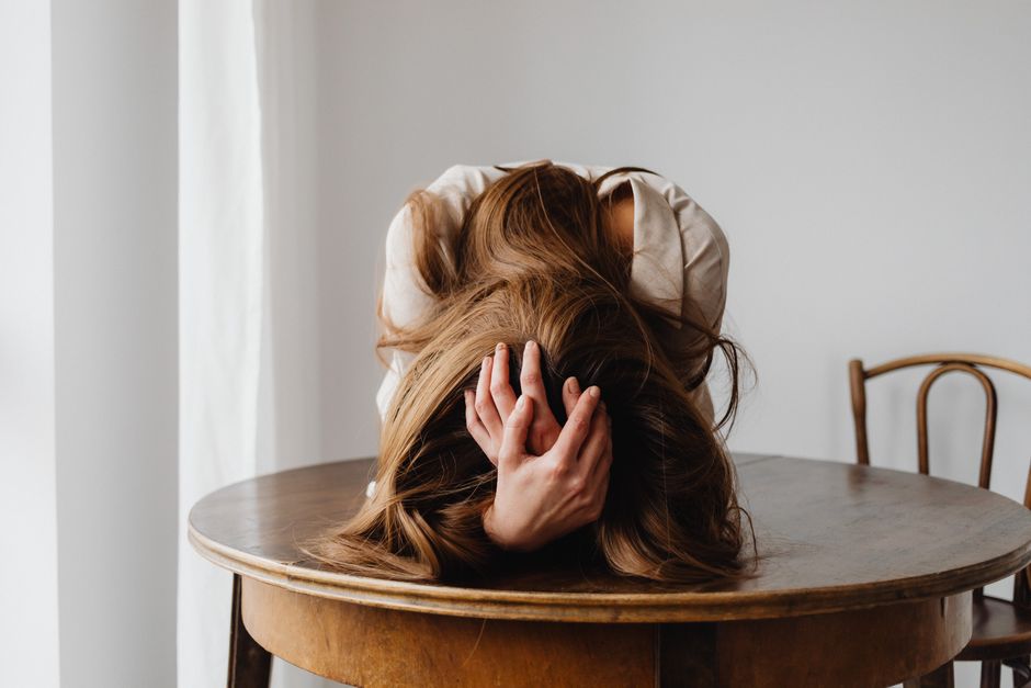 Person feeling isolated and overwhelmed in a relationship, sitting alone