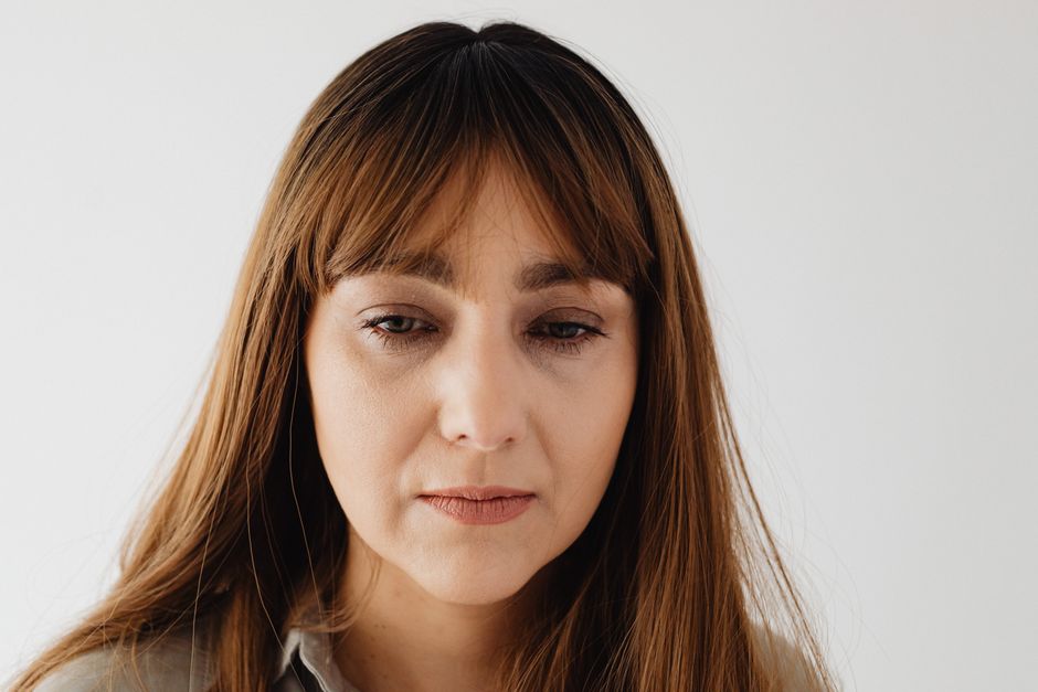 Person looking tired and withdrawn despite a neutral expression