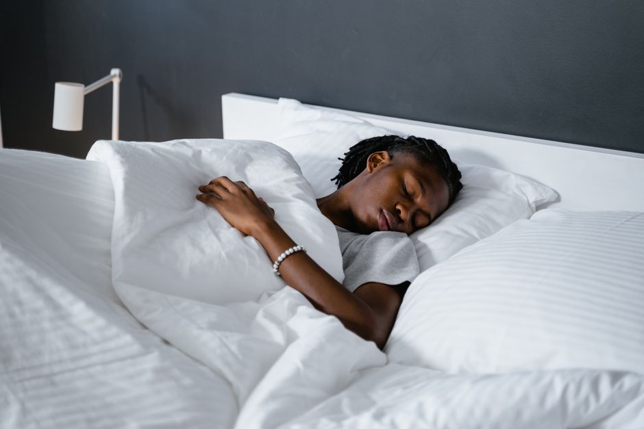 Person sleeping peacefully in a dark bedroom