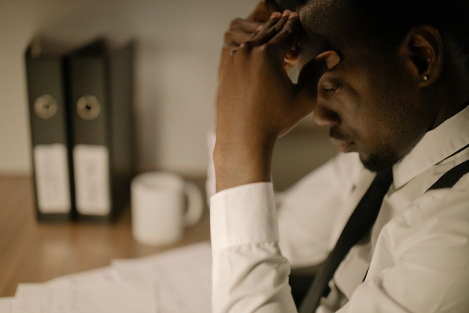 Personne en posture de stress avec ordinateur et tasse de café