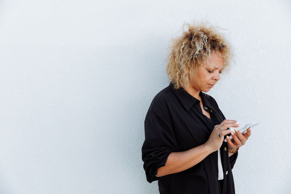 Person looking worried while checking messages on a phone