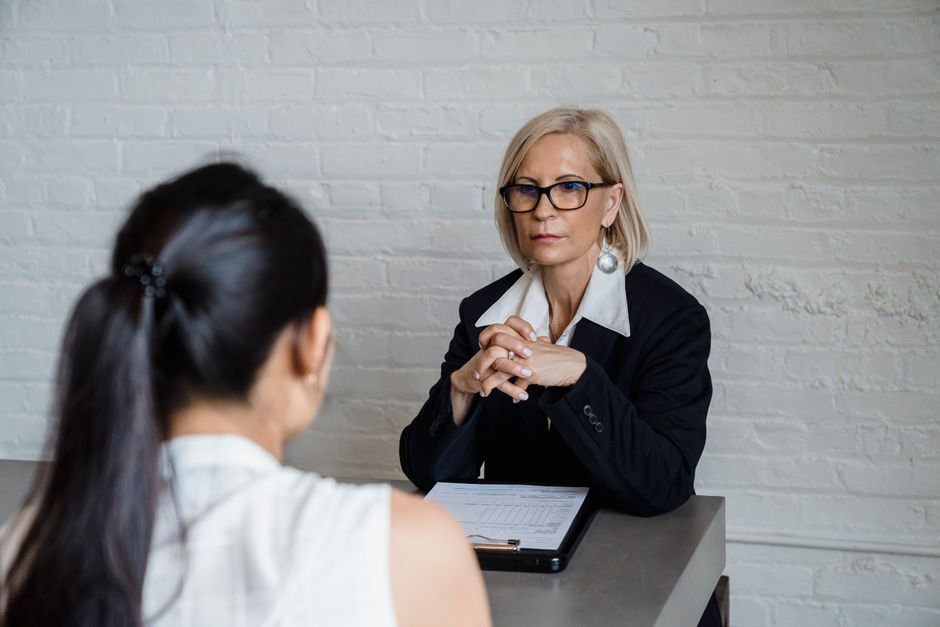 Supportive coaching conversation between mentor and employee in a modern office