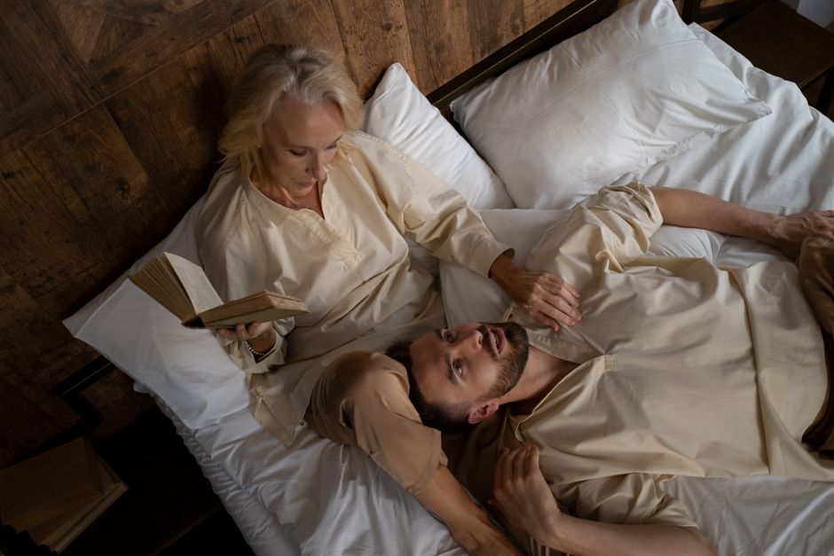 Couple lying together in a relaxed, intimate moment with soft light
